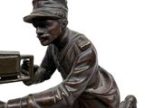 bronze statue of a man with a machine on a rock