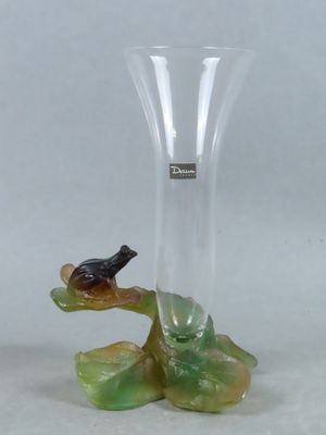 un vase en verre sur lequel est perché un oiseau