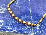 un gros plan d'un collier posé sur une surface en marbre bleu