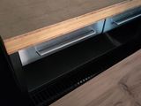 a wooden counter top with a metal drawer underneath it