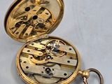 a gold pocket watch inside of it on a white surface