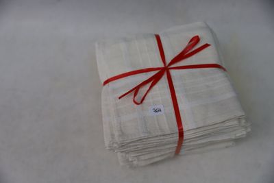 a stack of white napkins tied with a red ribbon