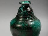 a green vase that is sitting on a table