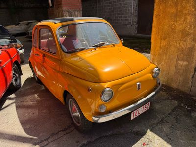 une petite voiture jaune garée à côté d'une voiture rouge