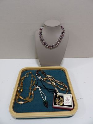 un plateau sur lequel sont posés un collier, des bracelets et un autre collier