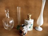 three glass vases and a glass bottle on a table