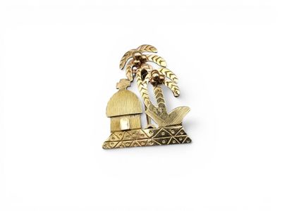 une image représentant une broche plaquée or ornée d'un palmier