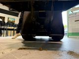 a person standing underneath a vehicle in a building