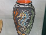 un vase orné d'un hippocampe, exposé dans une vitrine