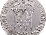 a close up of a silver coin with a crown on it
