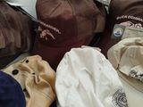 many hats that are sitting on a bed together