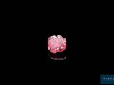a close up of a pink diamond on a black surface