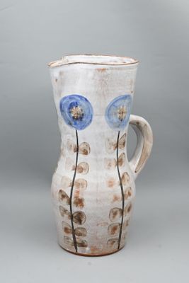 un vase blanc orné de fleurs bleues sur fond gris