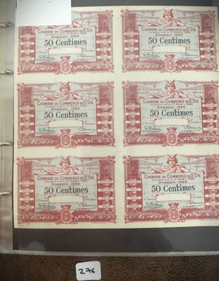 Six anciens billets de banque rouges et blancs sont exposés dans une vitrine.