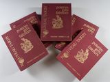 six livres rouges ornés de dorures, empilés les uns sur les autres