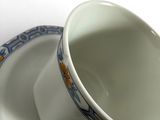 a white cup and saucer sitting on a plate