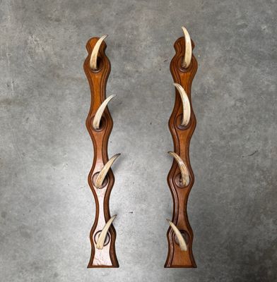 two pieces of wood with antelope carved into them sitting on a table