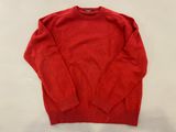 un pull rouge posé sur une table blanche