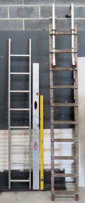 two ladders that are leaning against a wall