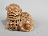 une petite figurine représentant un chien avec une balle