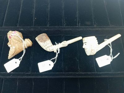 Plusieurs objets sont exposés sur une étagère noire dans une vitrine.