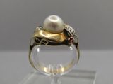 an image of a gold ring with a pearl and garnets