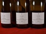 four bottles of wine are lined up on a table