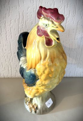 une figurine de coq jaune et noir posée sur une table