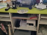 a computer desk with a monitor and printer on it