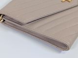 beige leather wallet with gold chain and zipper closure on a white surface