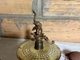 a small brass object on a table next to a cloth