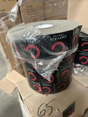 deux rouleaux de ruban adhésif noir et rouge posés sur une boîte en carton
