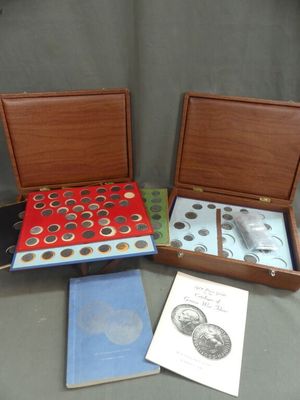 three boxes of coins and a book on a table