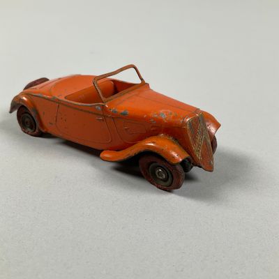 an orange toy car sitting on top of a white surface