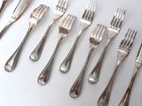 a lot of forks and spoons that are on the table