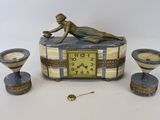 a statue of a woman laying on a table next to a clock