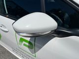 a white car with a green logo on the side of it