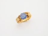 une bague en or avec une pierre bleue au centre