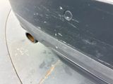 a close up of a car ' s bumper with a hole in it