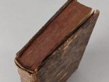 an old book sitting on top of a table next to a white table