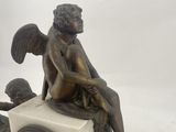 a statue of an angel sitting on top of a clock