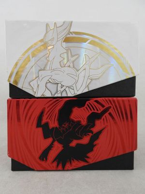 Deux boîtes de cartes à collectionner Pokémon sont posées sur une table
