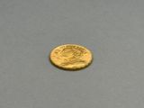 a close up of a gold coin on a gray surface