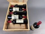 bottles of wine in a wooden box with a bottle of wine next to it
