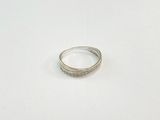 une bague en argent posée sur une surface blanche