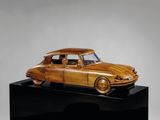 une photo d'une maquette en bois de voiture posée sur un socle noir