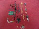 a lot of jewelry that is laying out on a red surface