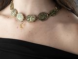 une femme en robe noire portant un collier en or