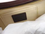 the inside of a brown and white purse with a white bag underneath it