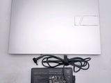 a laptop that is sitting on a table with a charger attached to it